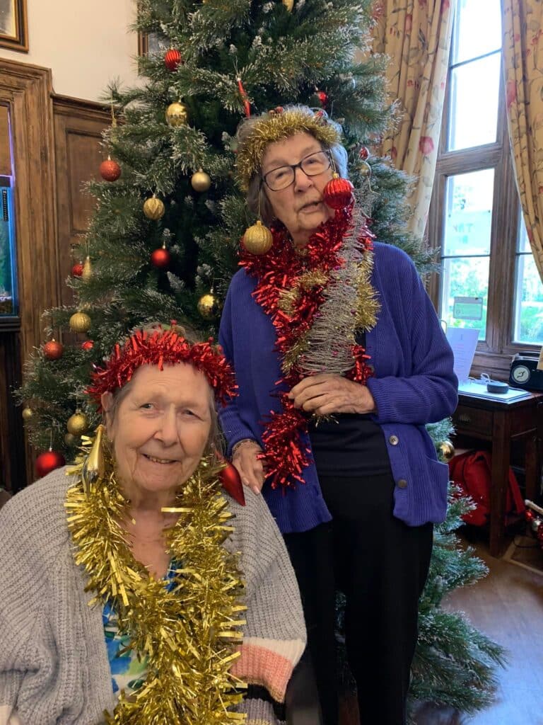 two lady residents with tinsel decorations and baubles