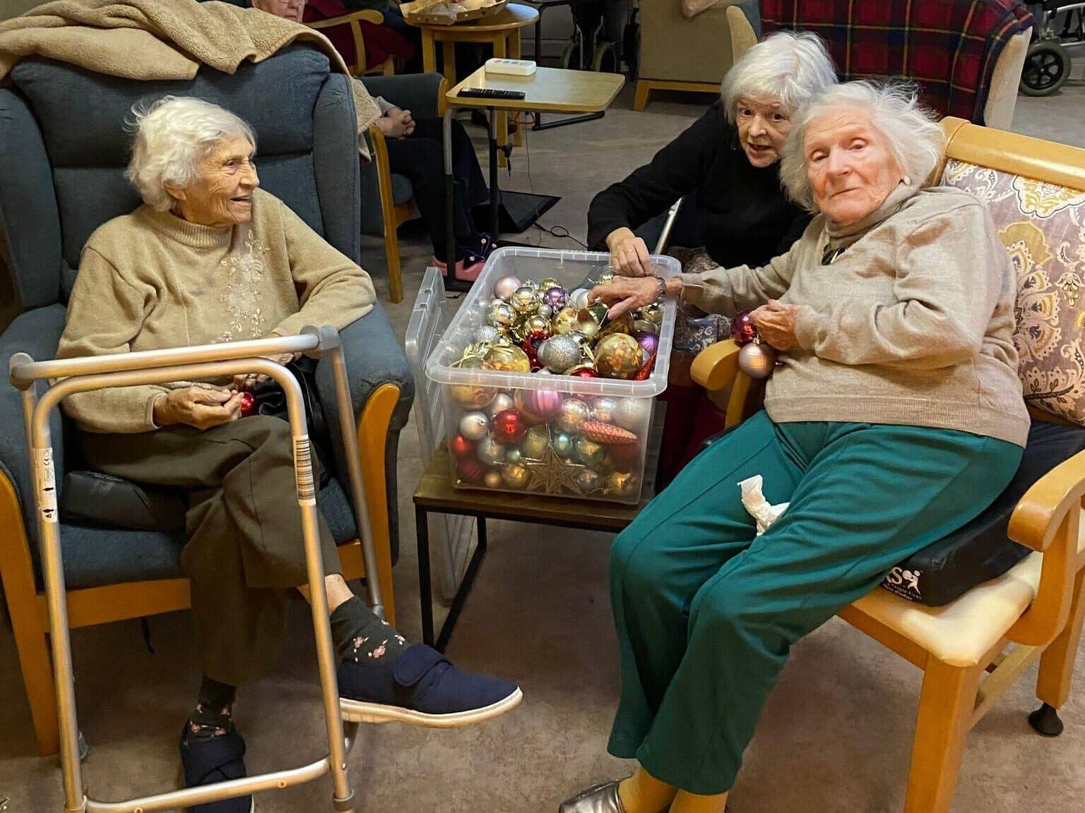 3 lady residents chatting sorting baubles for Xmas