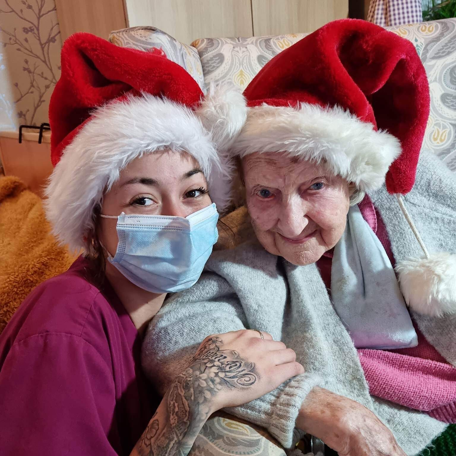 resident and carer in santa hats