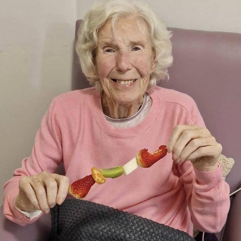 resident in pink top with fruit kebab